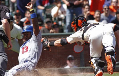 Dodgers shortstop Hanley Ramirez slides for the score at home plate as Giants catcher Buster Posey tries to tag him out. (AP Photo)